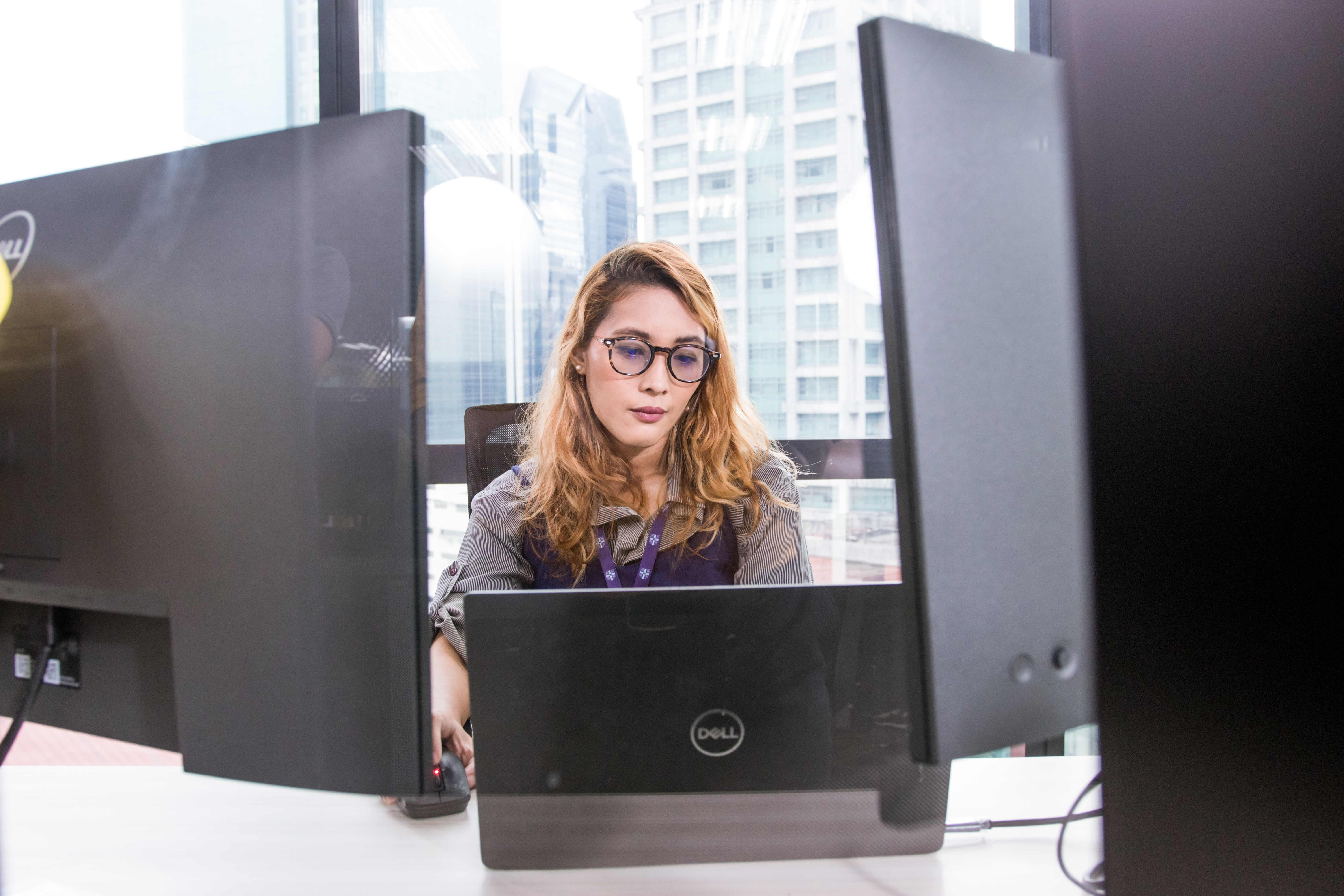 A colleague busy working in the office in Manila in front of a laptop 