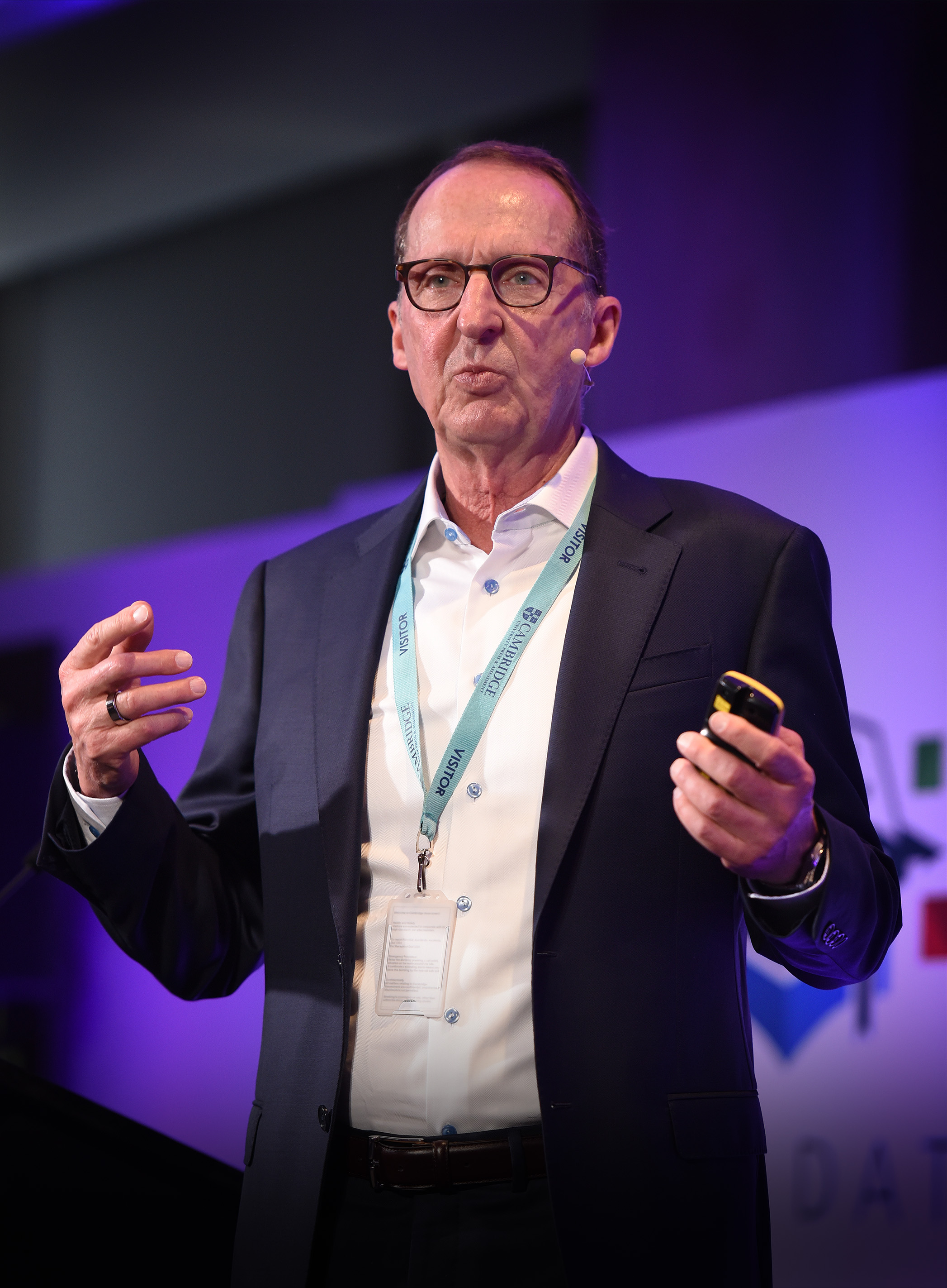 Philip Regier stands on stage holding a remote delivering his keynote speech at Digital & Data Day