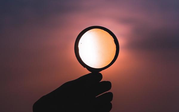 A hand holding a magnifying glass.