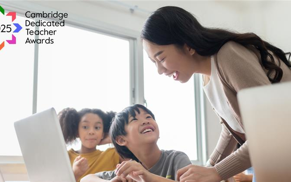 Image of a teacher teaching her young students using a laptop in a classroom setting having a fun class.