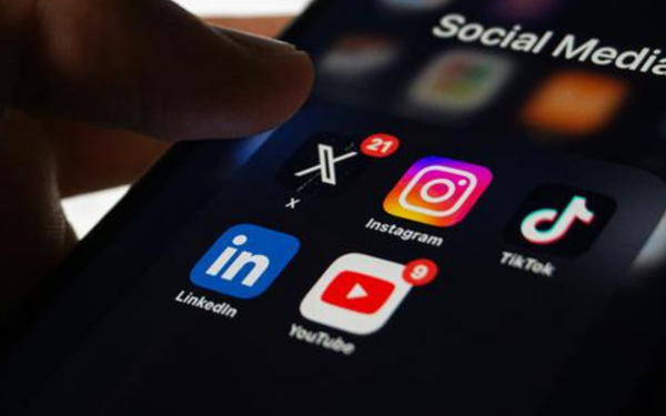 A person holding a smart phone with social media on the screen