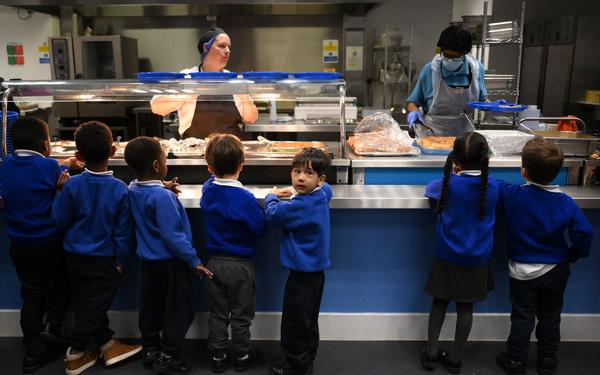 Children wait in line for school lunch