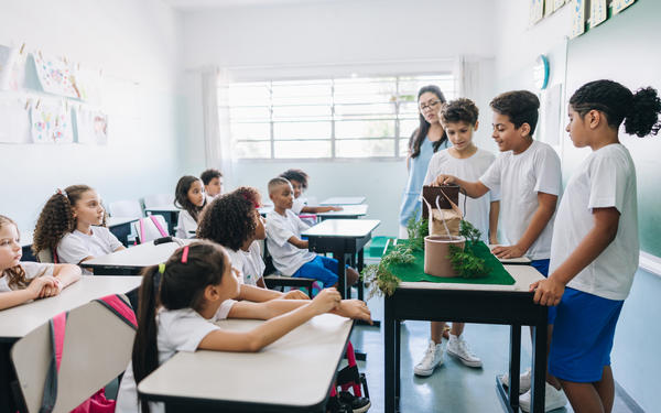students doing presentation in classroom with green plants