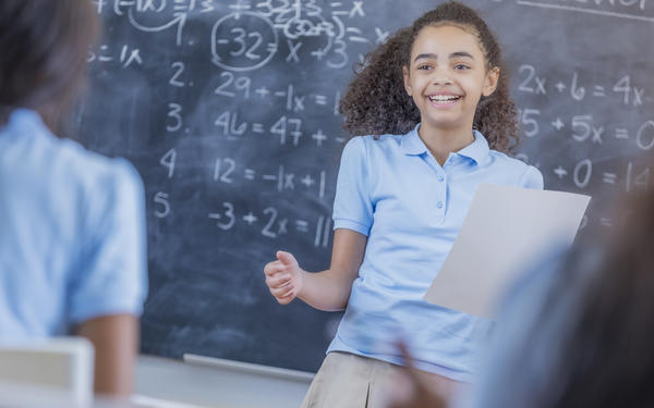 Girl presents Maths work in class
