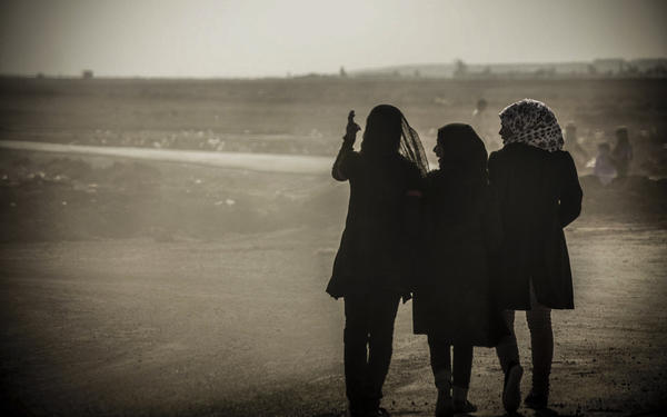 black and white photograph of the back of three women 