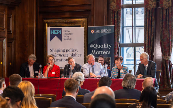 Panel of six speakers at the OECD event launch, seated at a table with HEPI and Cambridge University Press banners behind them.