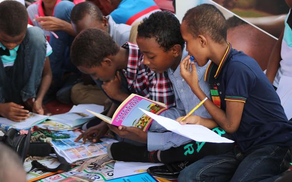 Children reading books and filling out activity books