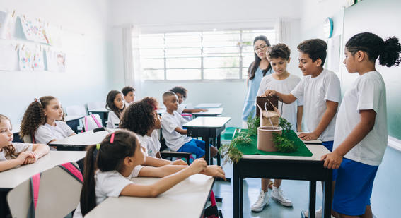 students doing presentation in classroom with green plants