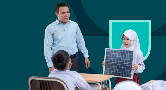 Young female student showing solar panel to young male student alongside teacher