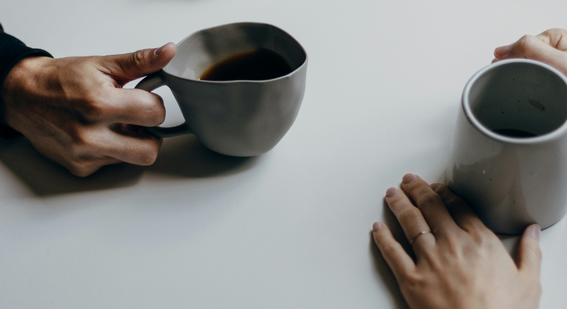 people in conversation with mugs