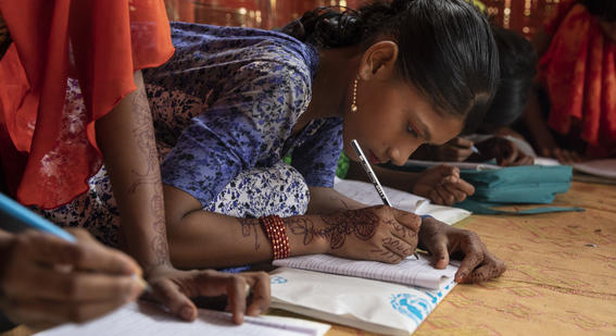 Girls learning and writing in a refugee camp