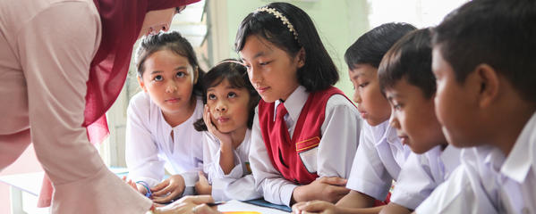 Malaysian students with teacher in classroom